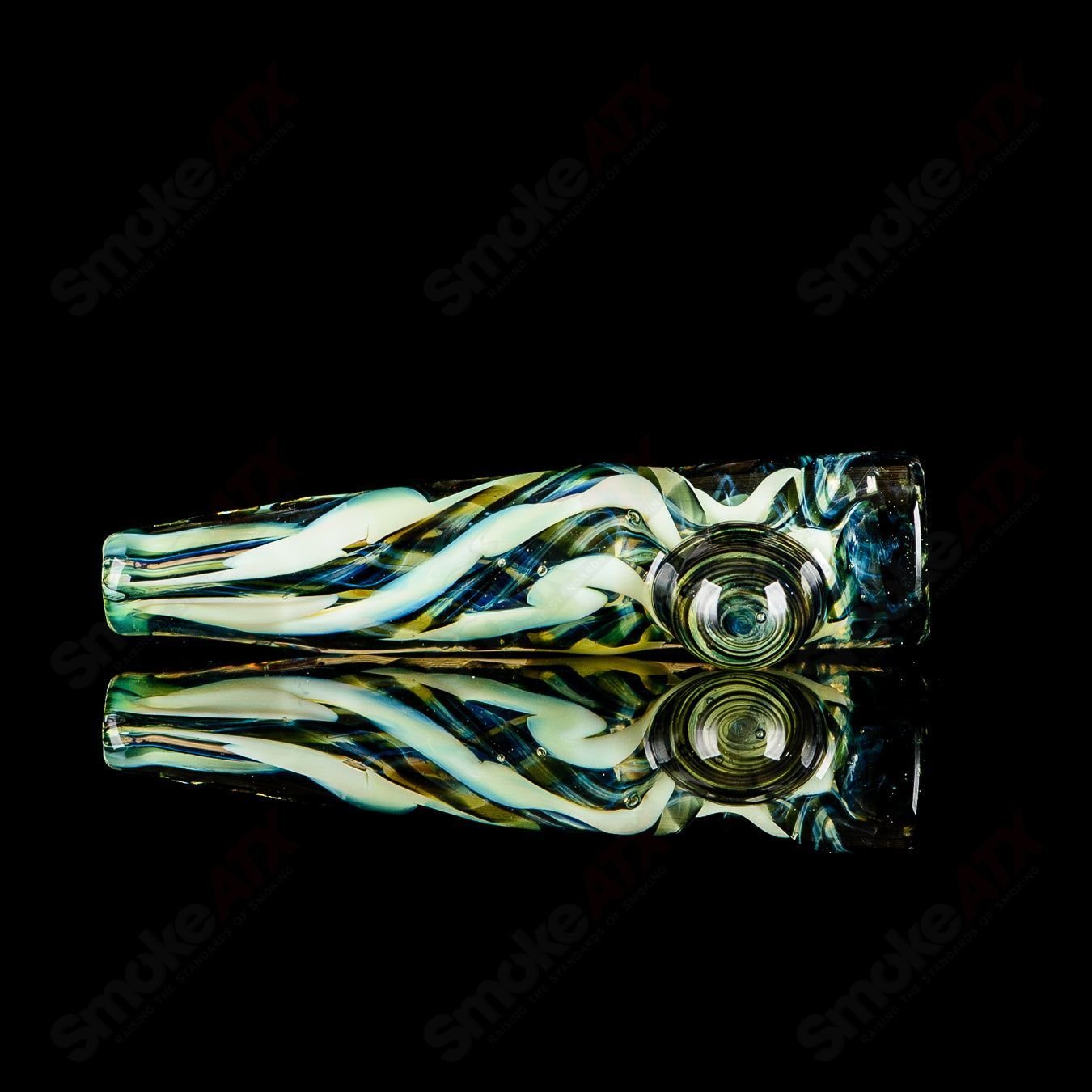 Signed JMK Glass #10 I/O Worked Chillum made of clear glass with intricate worked design, displayed against a neutral background.