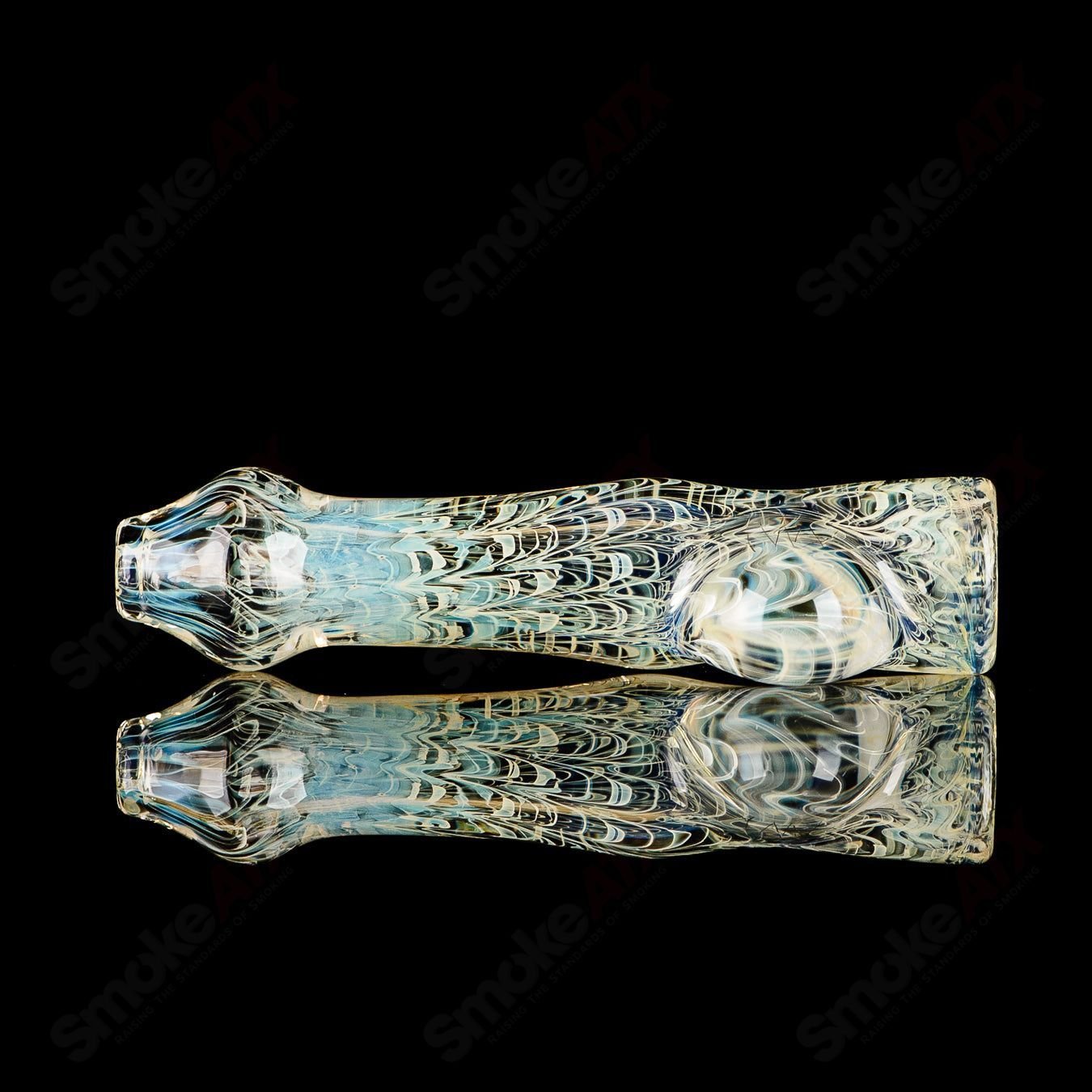 Transparent JMK Glass chillum with intricate worked design and clear dot signature, showcasing detailed glass craftsmanship.