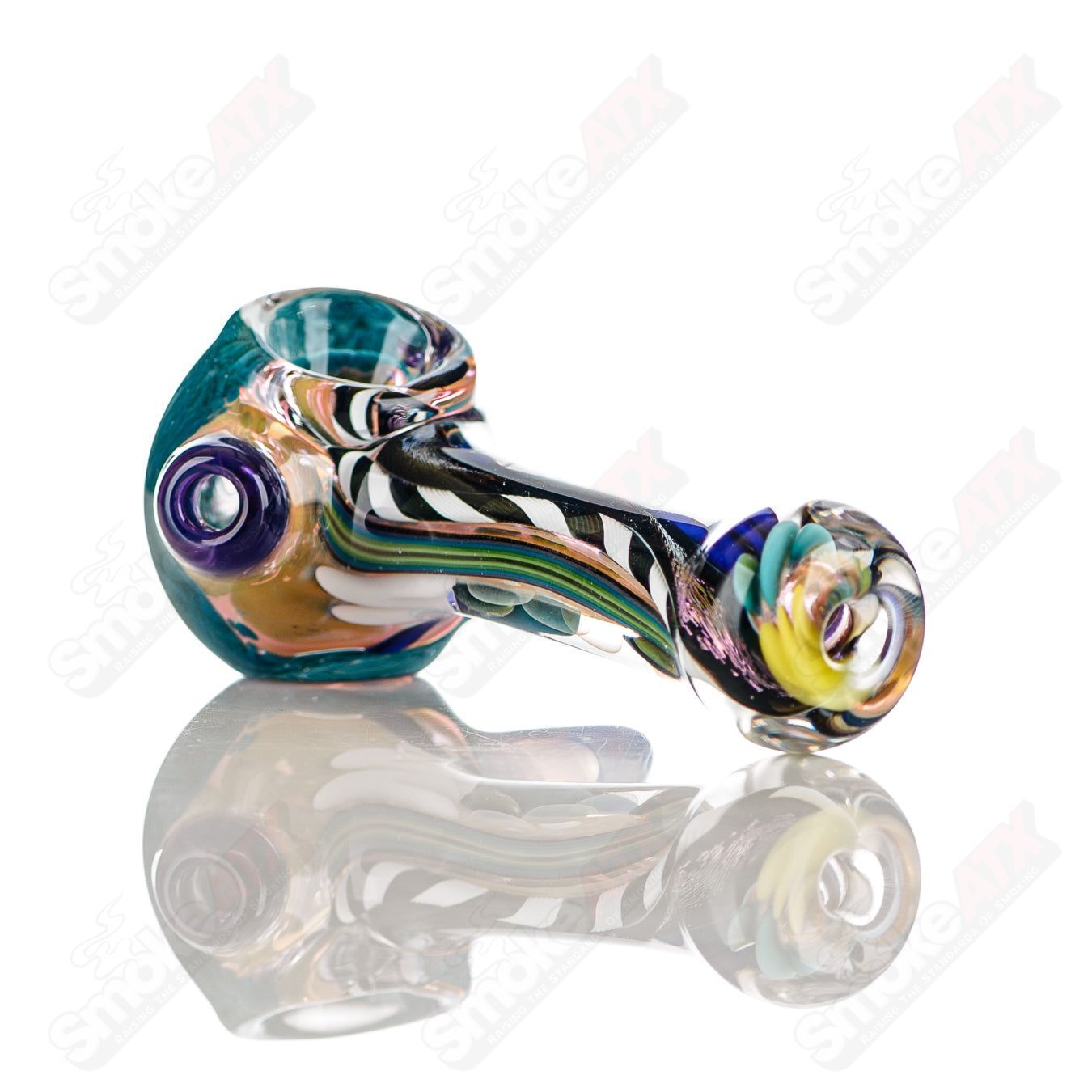 Colorfully worked IO spoon hand pipe by Jeremy from Oregon with four vibrant colors and intricate glass design.