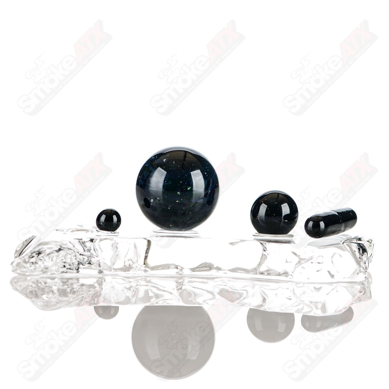 Set of four Indo Glass UV Black Magic galaxy, citrine, and Lucy slurper glass accessories with vibrant, colorful designs.
