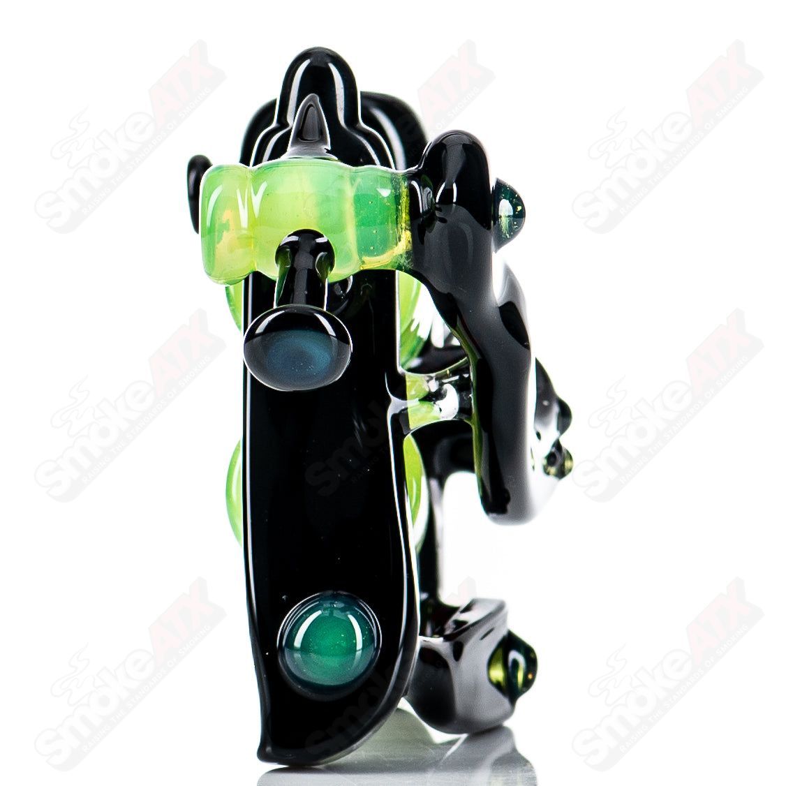 Black and slime-colored tattoo gun-shaped concentrate rig by JMass, featuring bold glass design for dabbing and concentrate use.
