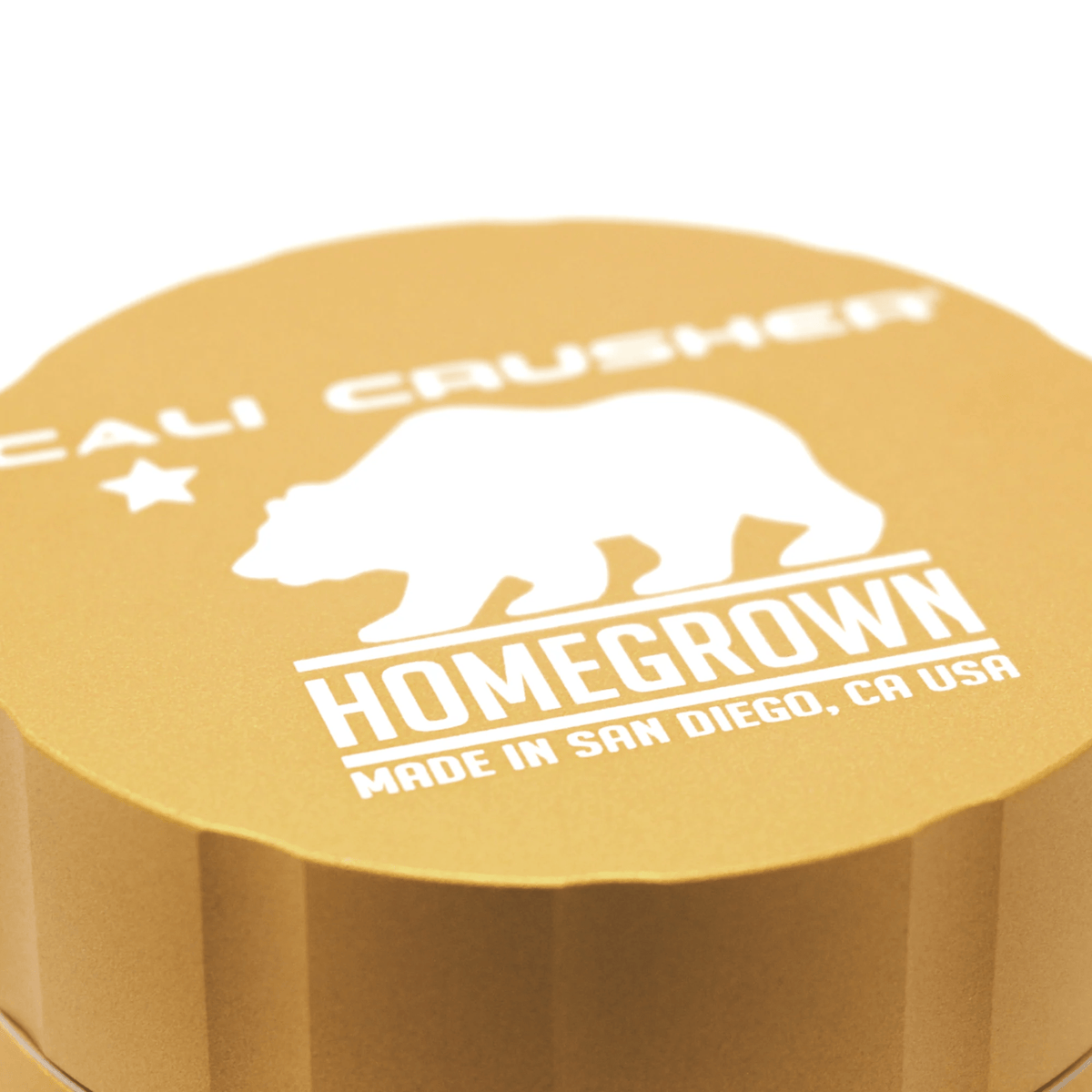 Cali Crusher 4-piece Homegrown Gold metal grinder with sharp teeth and gold finish, for grinding herbs and spices.