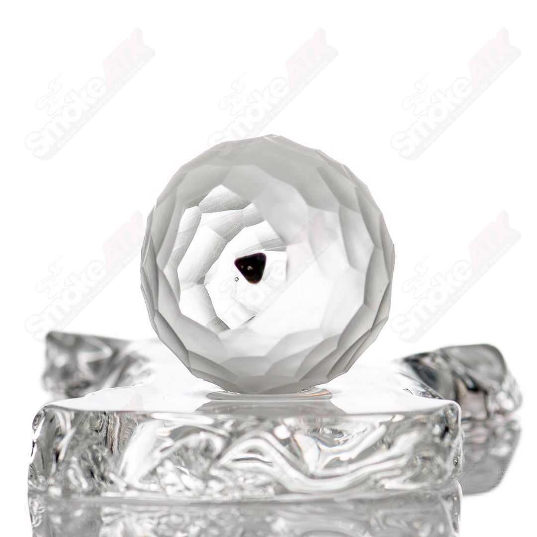 Faceted marble from Fatal Facets, glass marble with a smooth, polished surface and intricate faceted design.