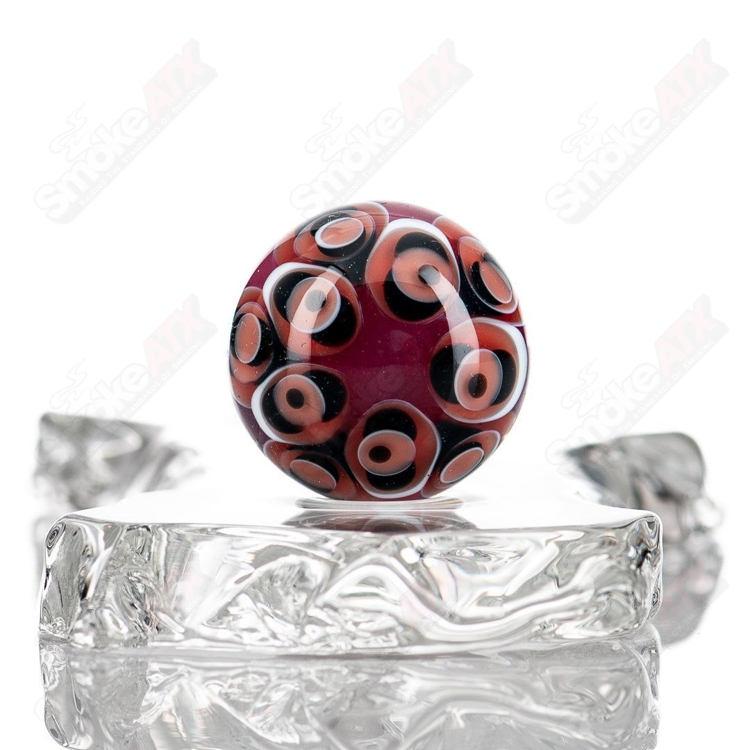 Red, black, and white dot-stacked glass marbles by Indo Glass, featuring vibrant colors and clear glass design.