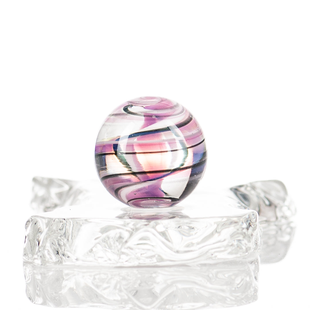 Colorful UV spiral marble by Indo Glass, made of glass, showcasing vibrant swirling patterns on a smooth, rounded surface.