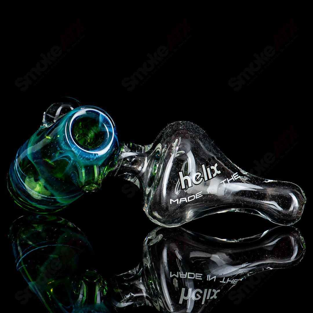 American Helix White Label Hammer glass pipe featuring a blue-green box fan helix design, showcasing intricate glass craftsmanship.