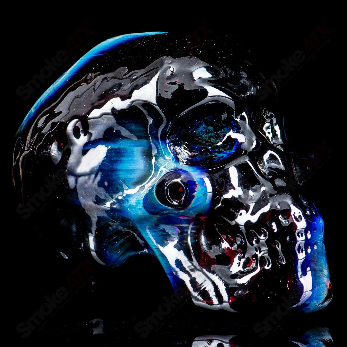 Fumed skull dry pipe by Team Snodgrass, heady glass hand pipe with a smoky, metallic finish and intricate skull design.