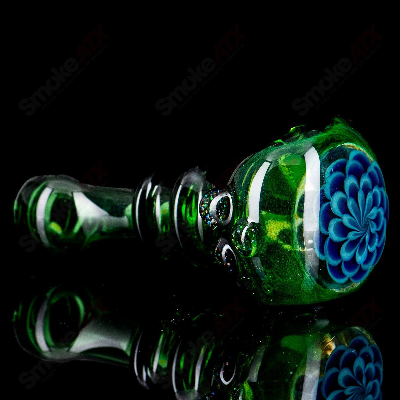 Green spoon hand pipe with crushed opal accents by JMass, featuring a smooth glass body and ergonomic shape.