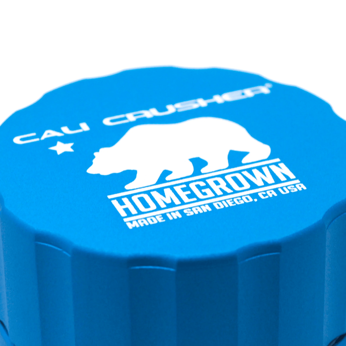 Pocket Cali Crusher 4-piece metal grinder with aquamarine finish, featuring sharp teeth and storage compartment for herbs.