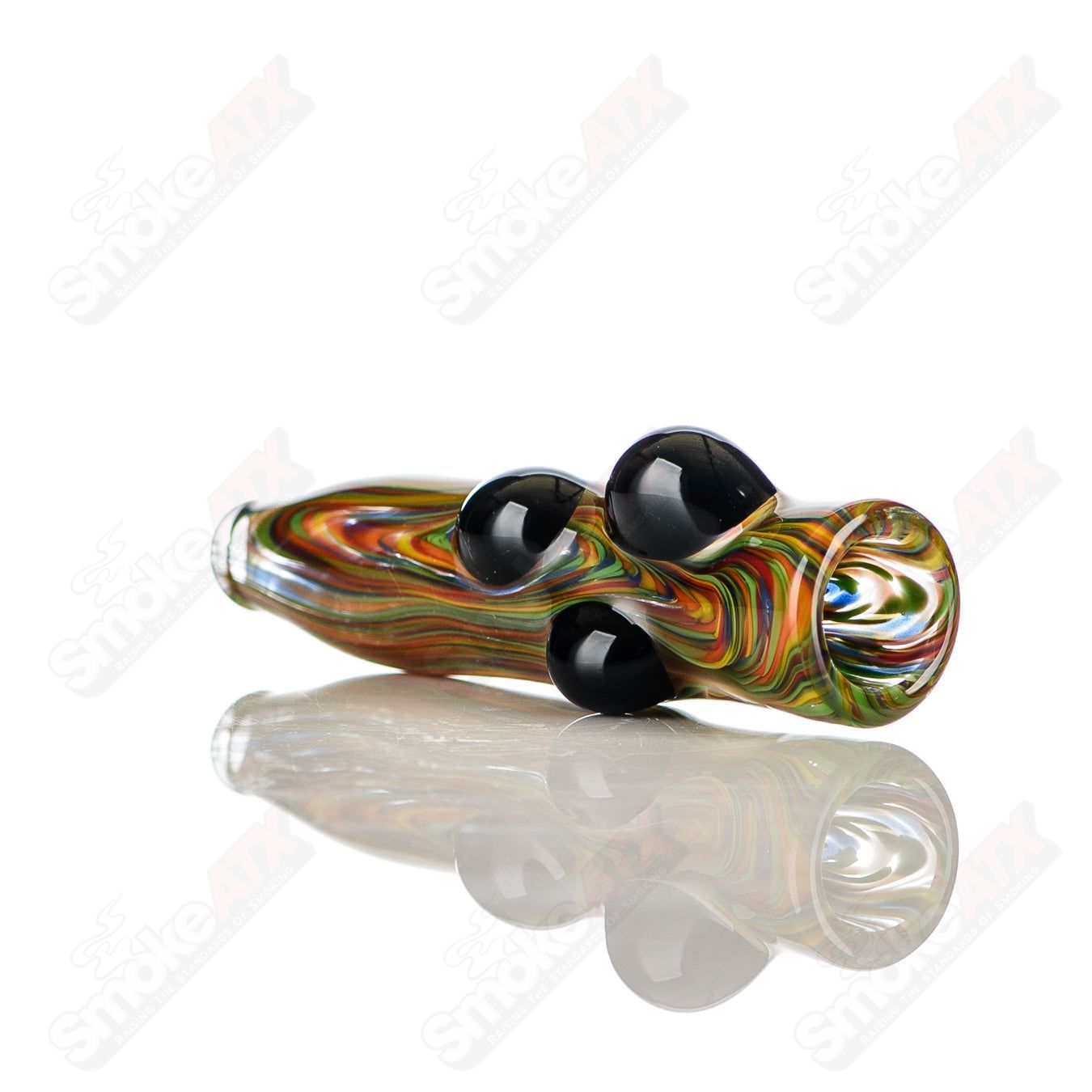 Rainbow-colored JMK Glass chillum with black dot accents, featuring intricate glasswork and signed craftsmanship.