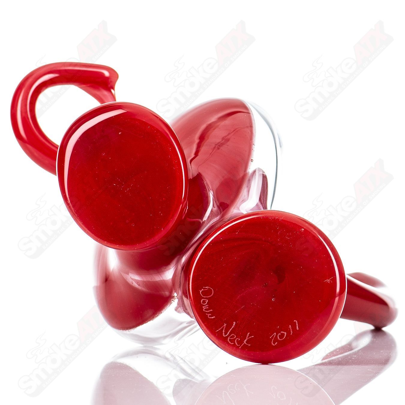 Red Jelly Head Rig by Down Neck Glass, 2011, a vibrant head-shaped bubbler with intricate glasswork and a clear base.