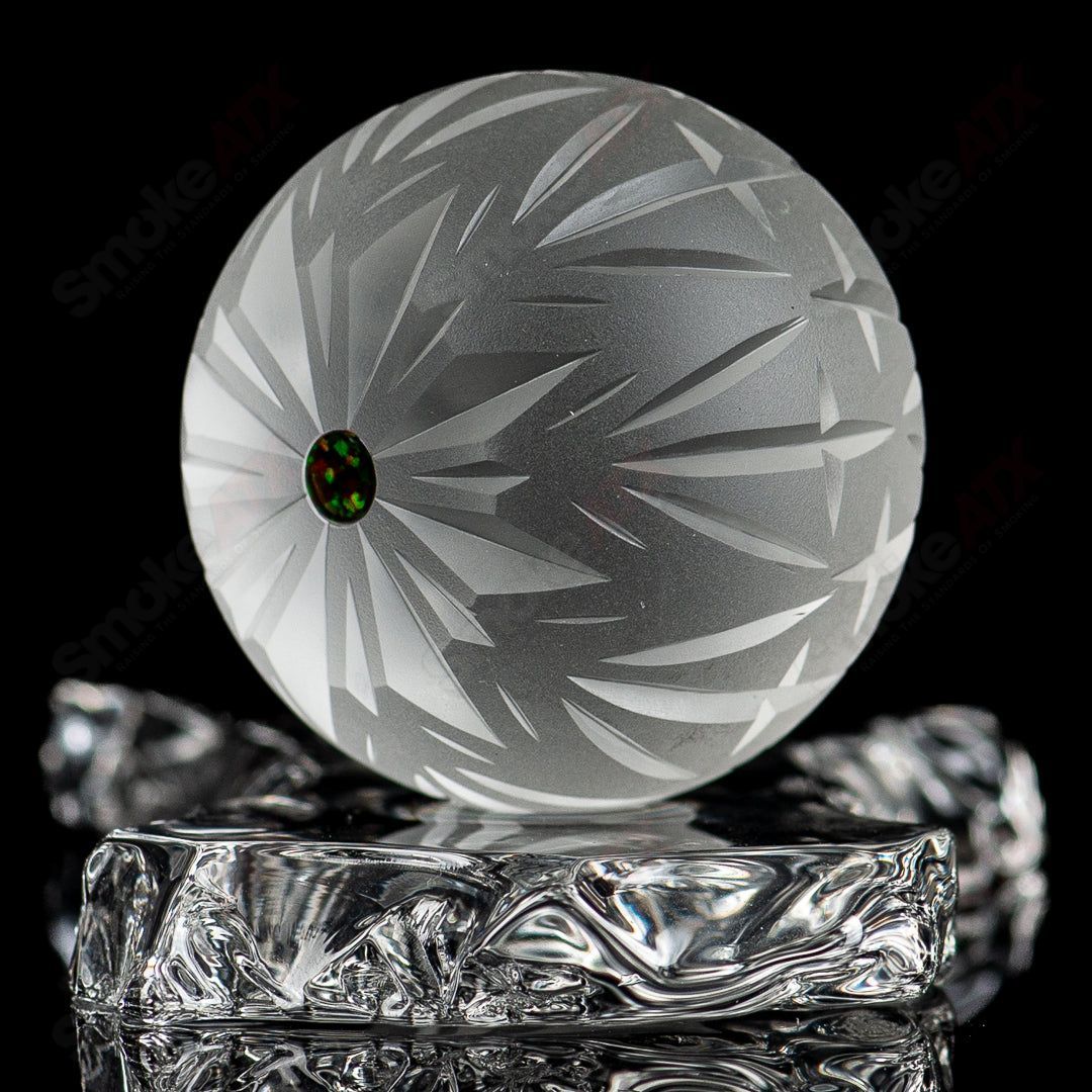 Faceted snowflake marble by Fatal Facets, glass marble with intricate snowflake design, shiny and smooth surface.