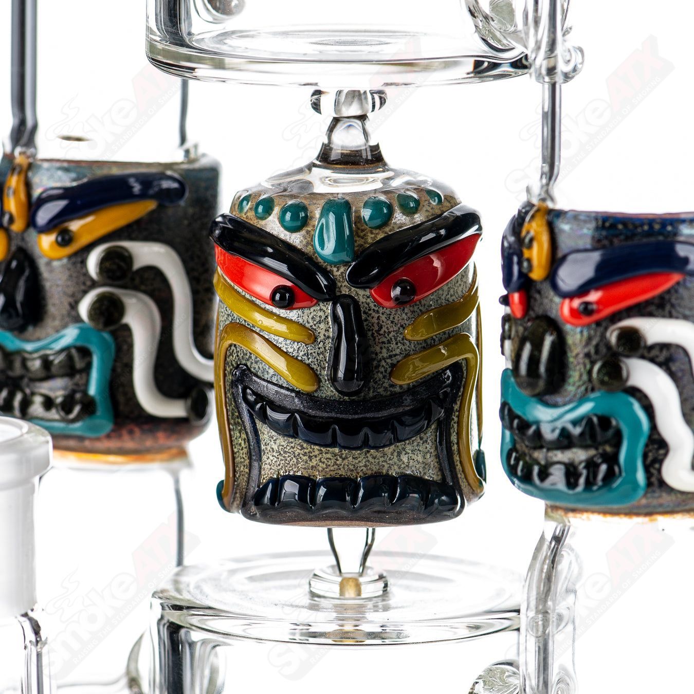 Spinning Tiki Head scientific tube by Carsten Carlile and Dirty Rico Glass, featuring detailed tiki head design and vibrant glasswork.