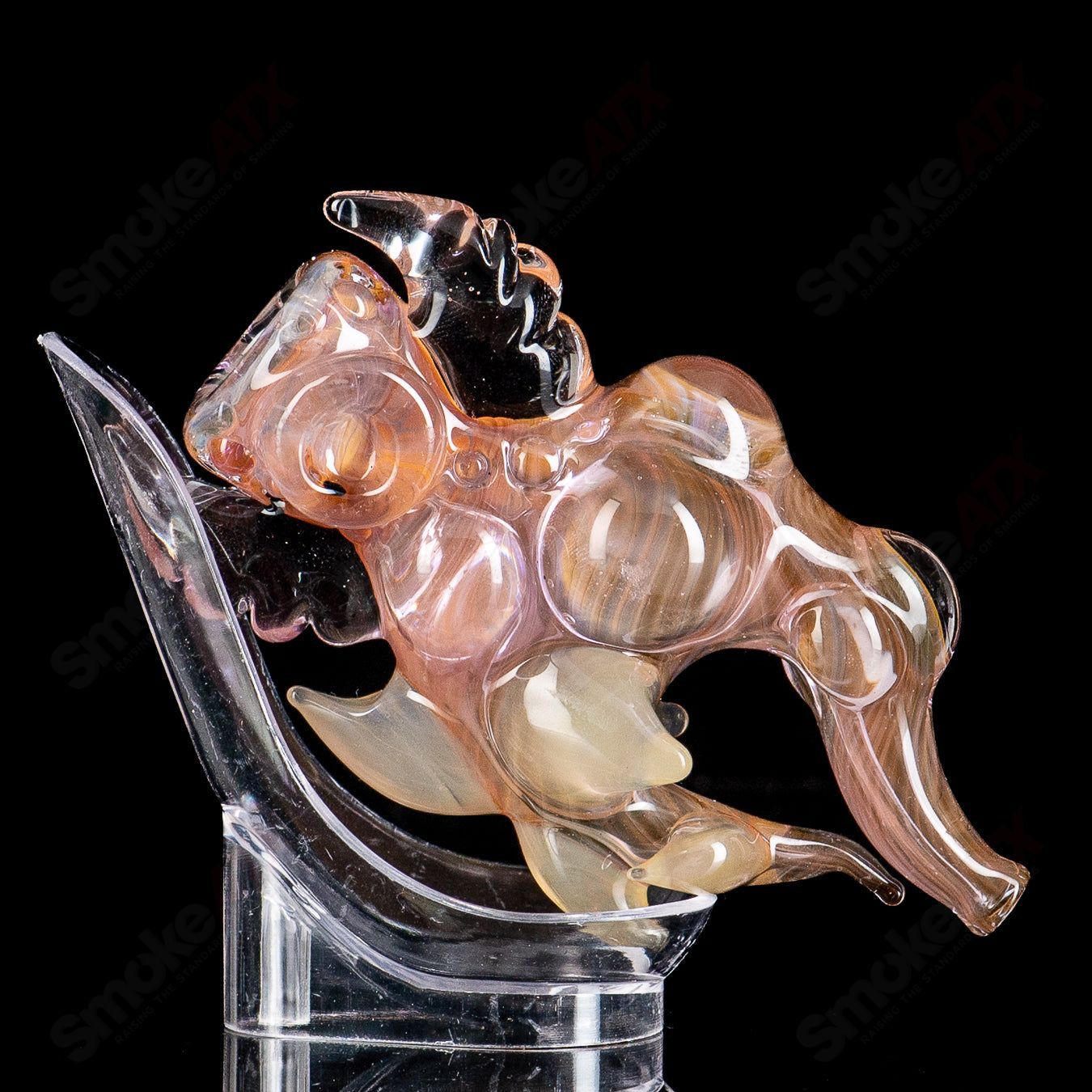 Shapely fumed glass chillum pipe by JMK Glass, featuring a smooth, curved design and smoky, iridescent finish.