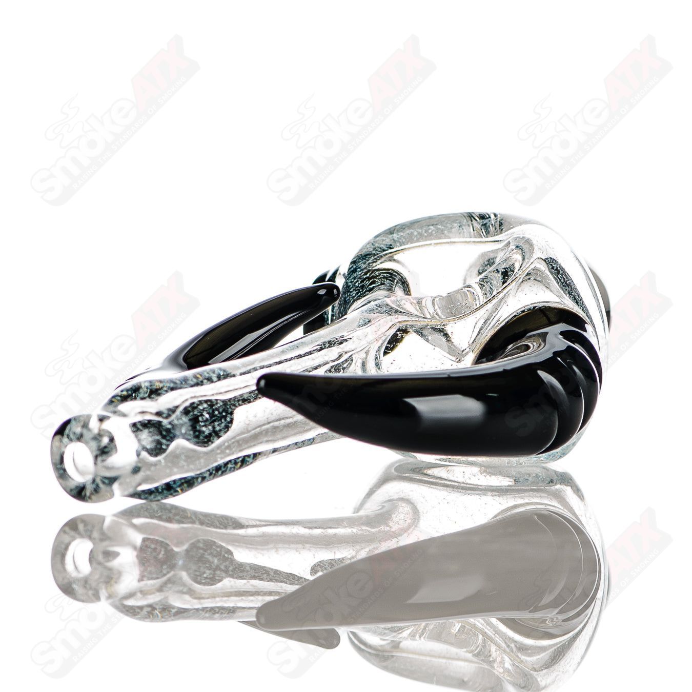 Clear dichro spoon hand pipe by JMK Glass with black horn accents and signature, featuring a transparent glass design.