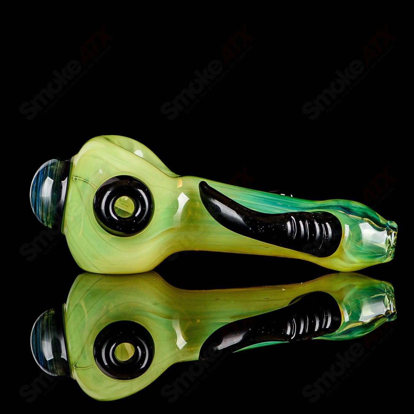 Transparent green glass spoon pipe with black horns and signature, handcrafted by JMK Glass, designed for smoking accessories.