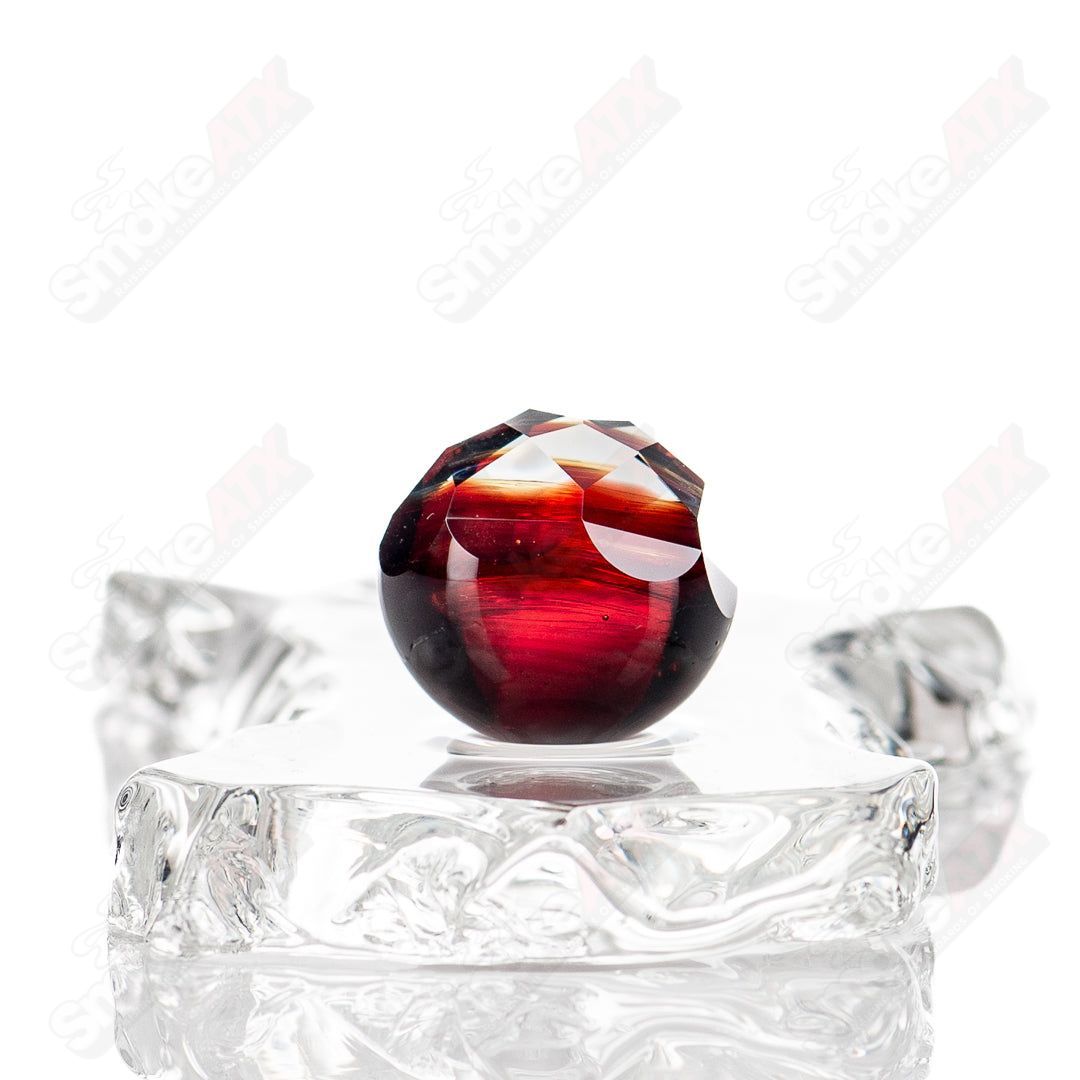 Faceted marble glass art piece by Fatal Facets featuring colorful, intricate faceted design on clear glass with vibrant marble accents.