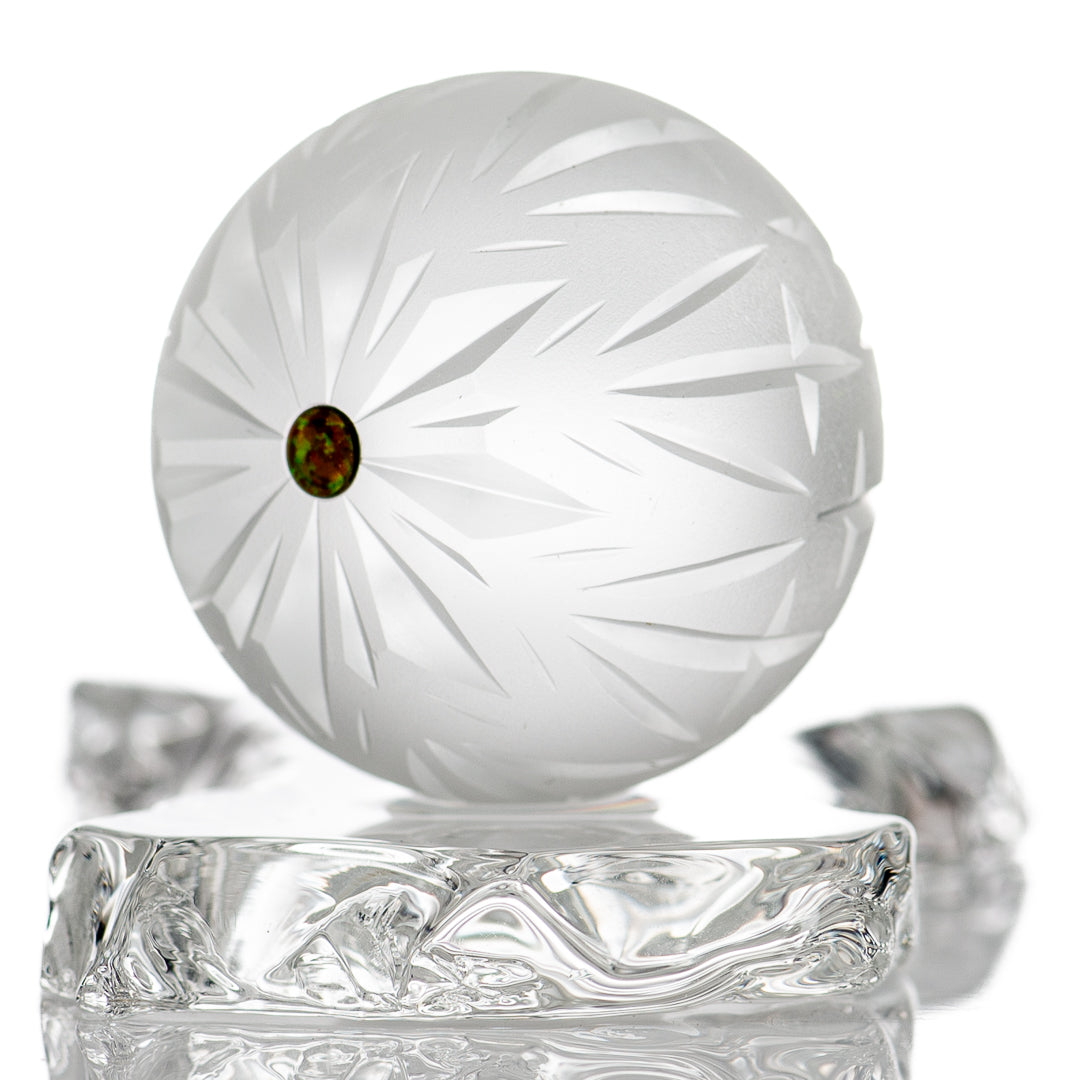 Faceted snowflake marble by Fatal Facets, glass marble with intricate snowflake pattern and shiny, reflective surface.