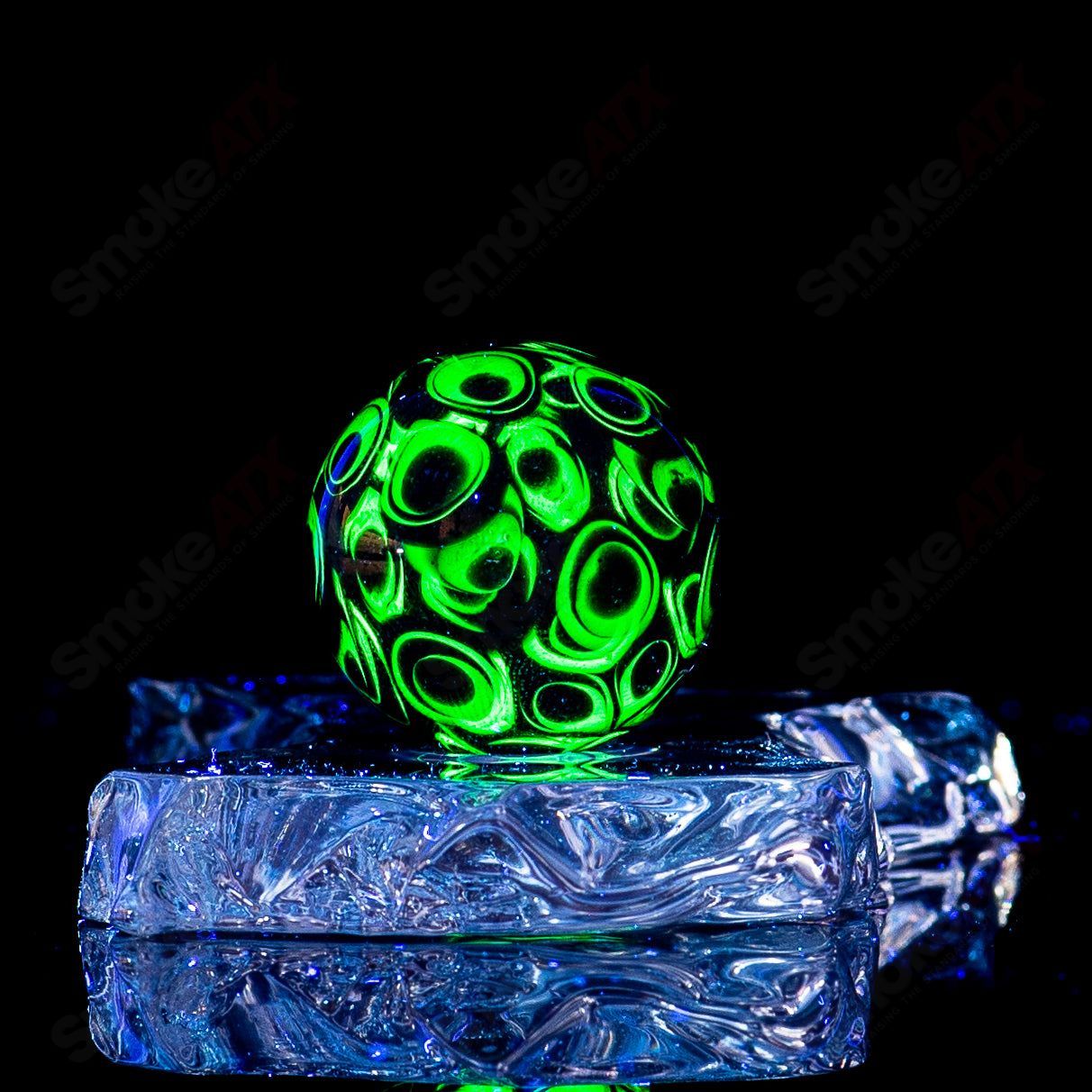 Colorful UV Dotstack MultiEye marble by Indo Glass, showcasing swirling marble patterns in transparent glass.