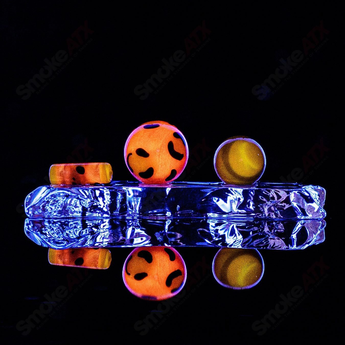 Three leopard-themed glass slurper sets from Adventures In Glass Blowing arranged on a display.