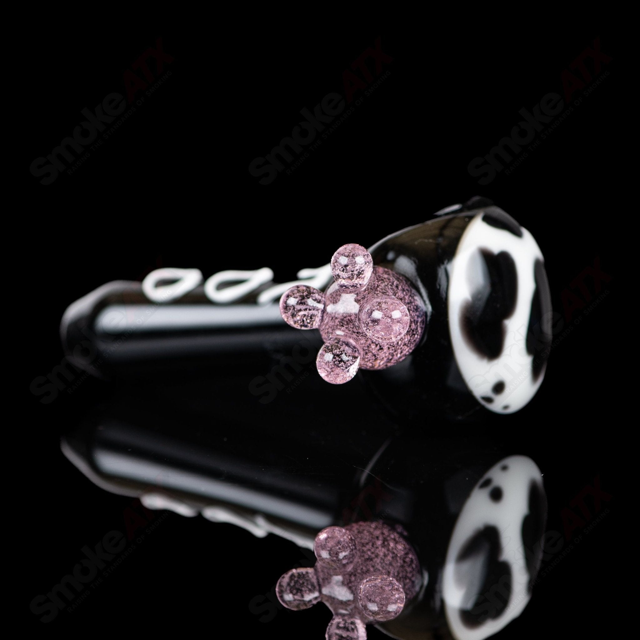 Black cow print glass spoon pipe by Adventures In Glass Blowing, featuring a smooth bowl and distinctive black cow pattern.