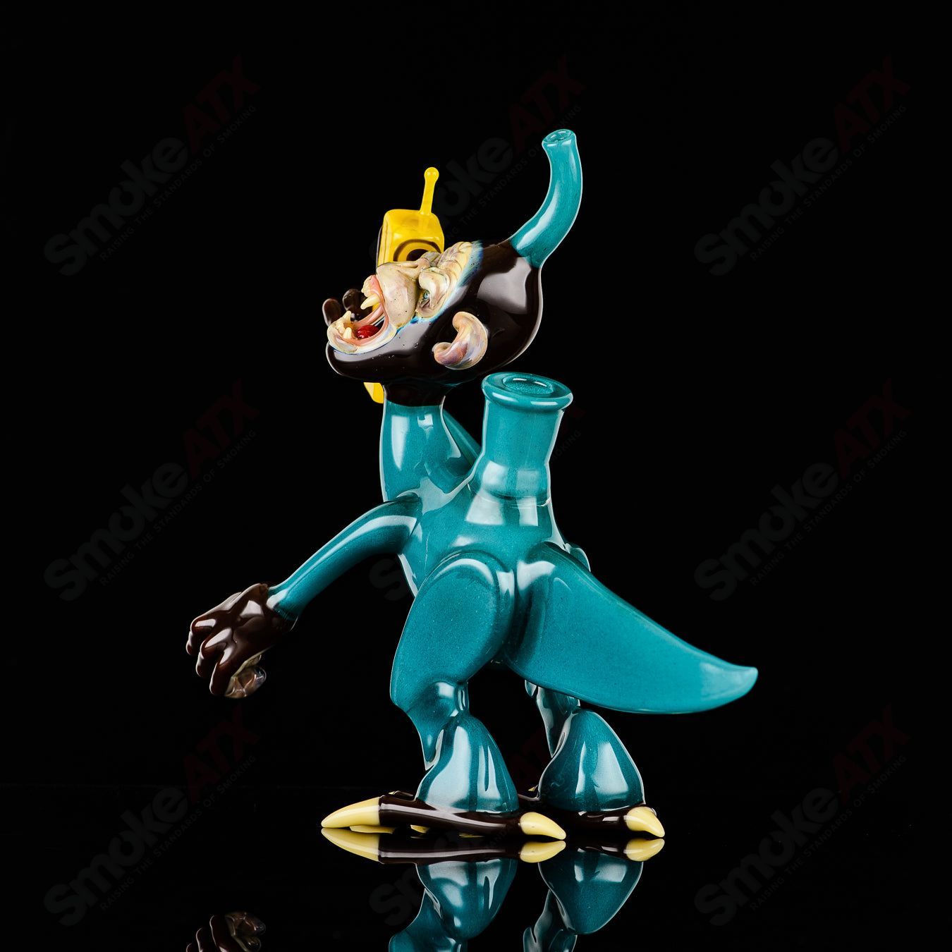 Elbo Glass Coyle x Elbo Dino Monkey heady glass concentrate rig with dinosaur and monkey design, clear glass with colorful accents.