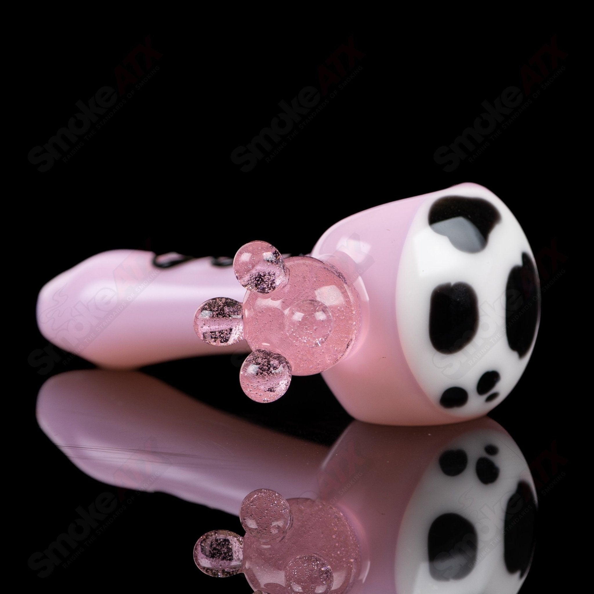 Pink cow print glass spoon pipe by Adventures In Glass Blowing, featuring a colorful cow pattern and smooth glass finish.