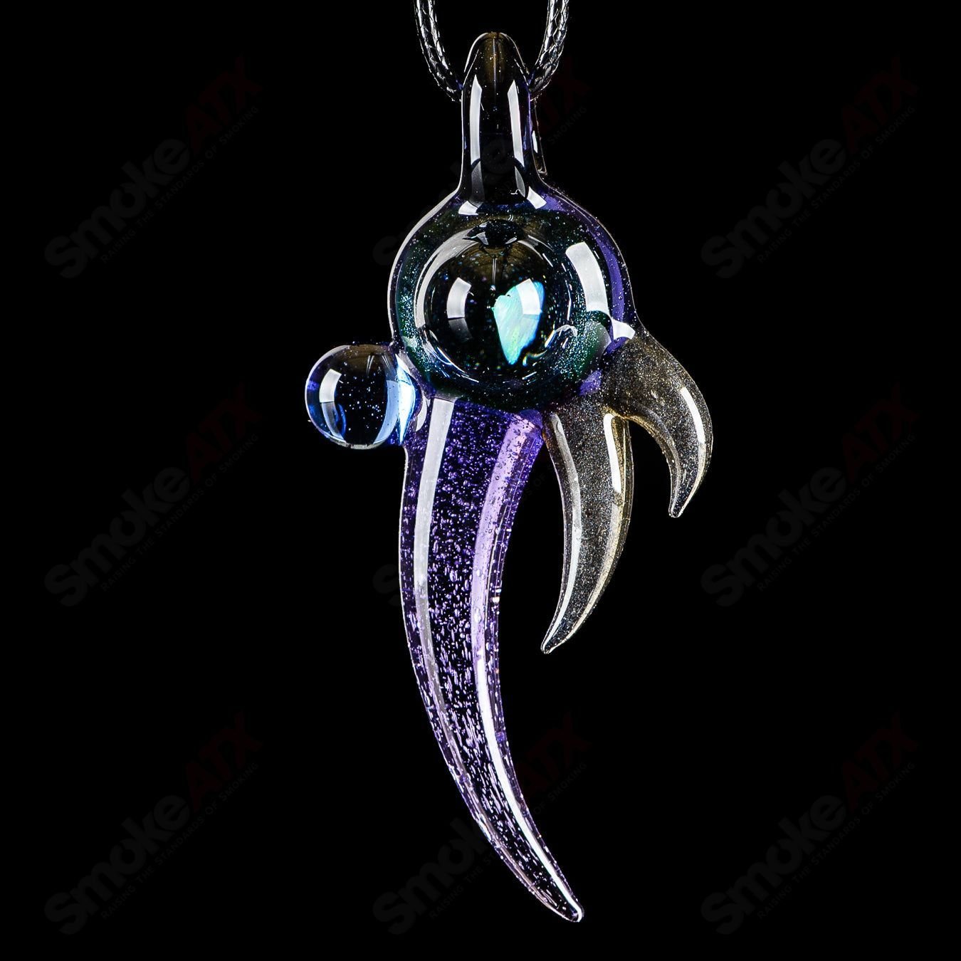 Dosh Glass amulet pendant with intricate glass design, hanging from a cord on a plain background.