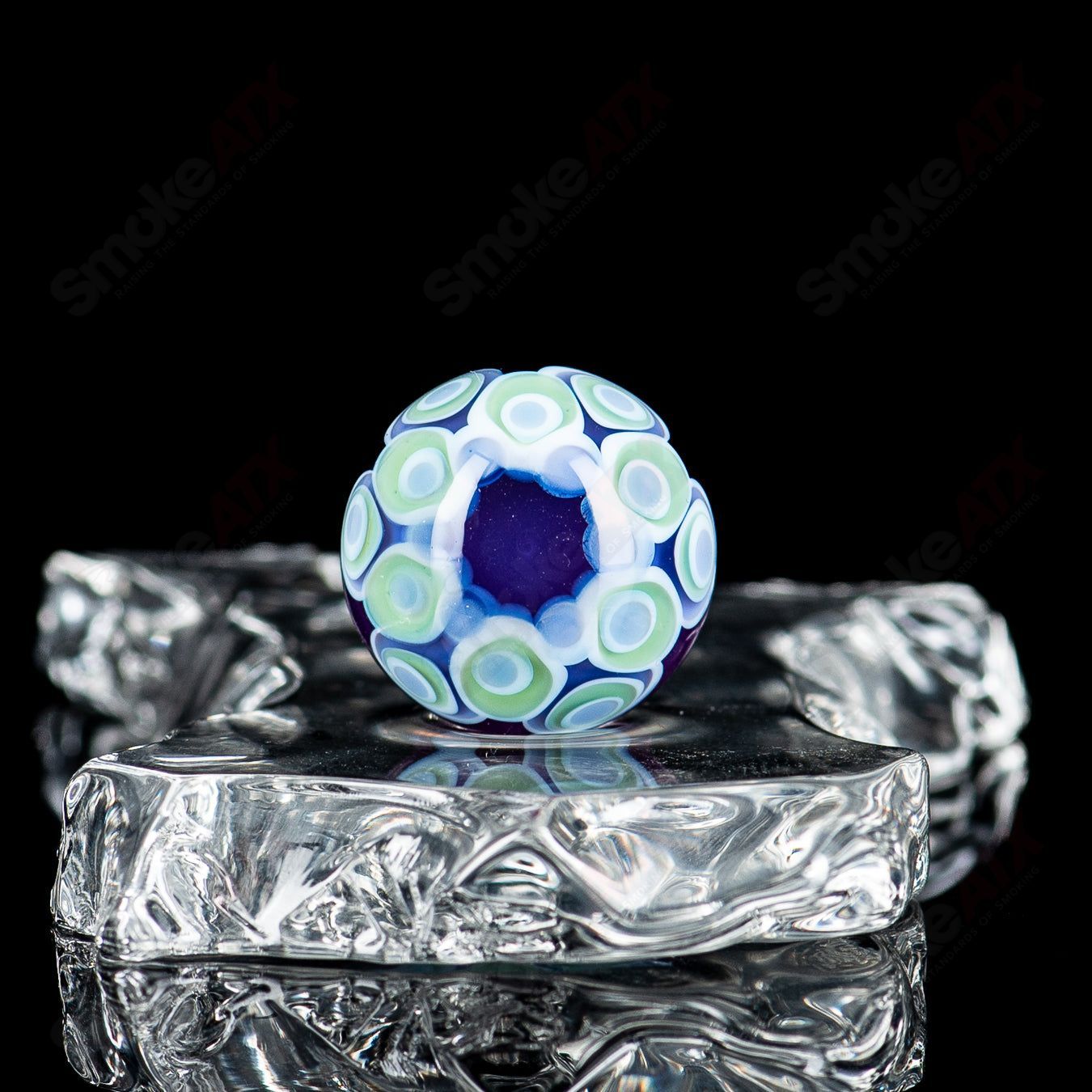 Glass marble with a stacked dot pattern from Indo Glass, featuring a clear design with a prominent dot top.