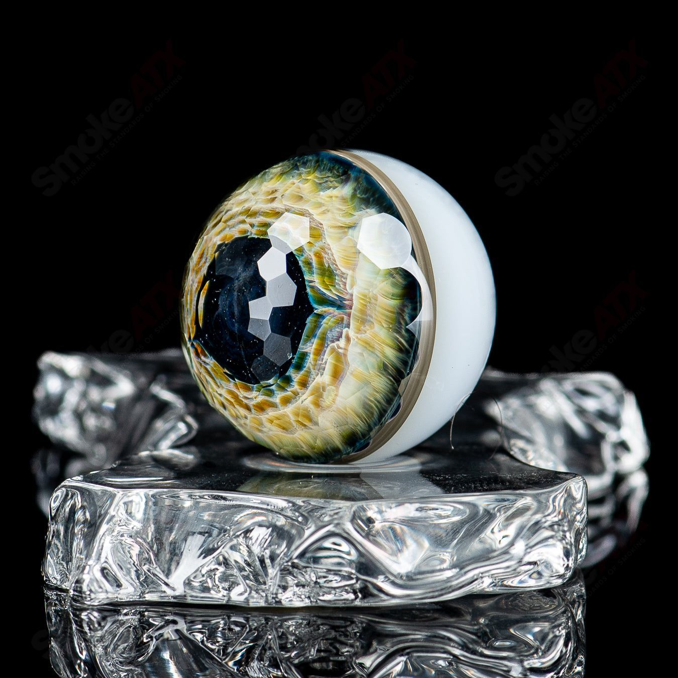 Indo Glass faceted eye marble with Indo Glass x Fatal Facets branding, featuring colorful, intricate glass detailing.