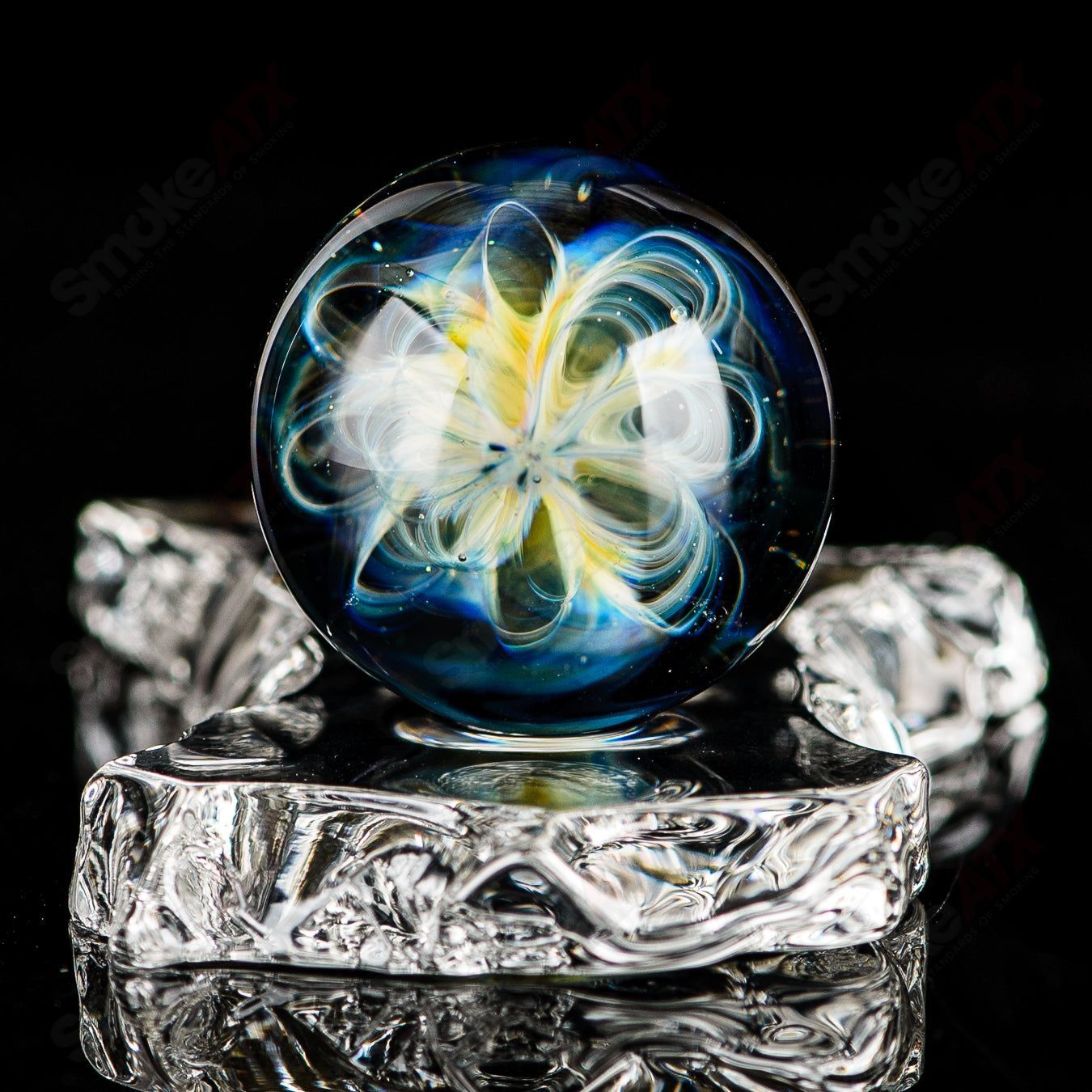 Fume Latticino marble signed by JMK Glass, colorful heady glass marble with intricate latticino design, artist signature visible.
