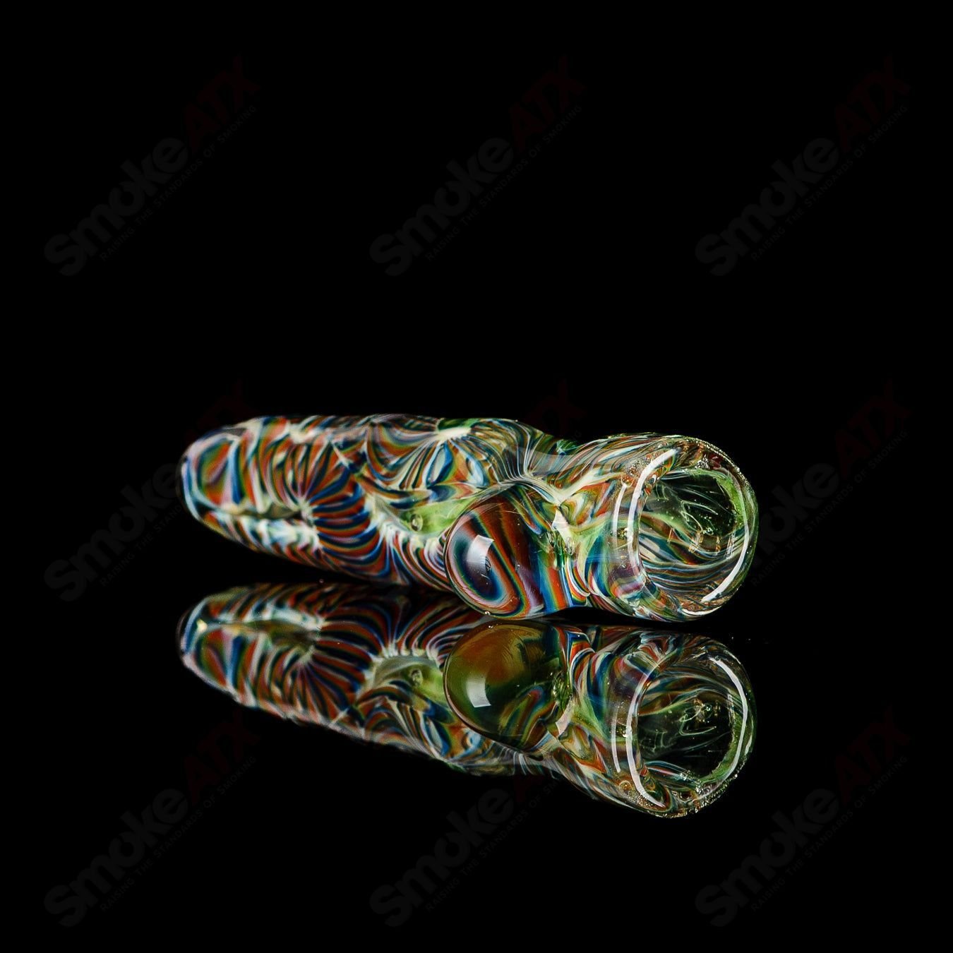 JMK Glass signed I/O Worked Chillum made of clear glass with intricate worked details and a smooth mouthpiece.