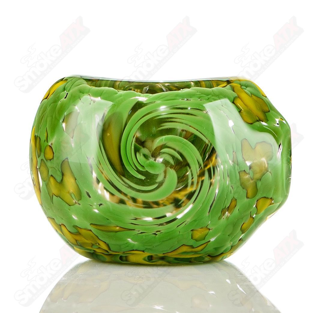 Green and yellow worked frit glass spoon pipe signed by JMK Glass, featuring intricate colorwork and a smooth, rounded shape.