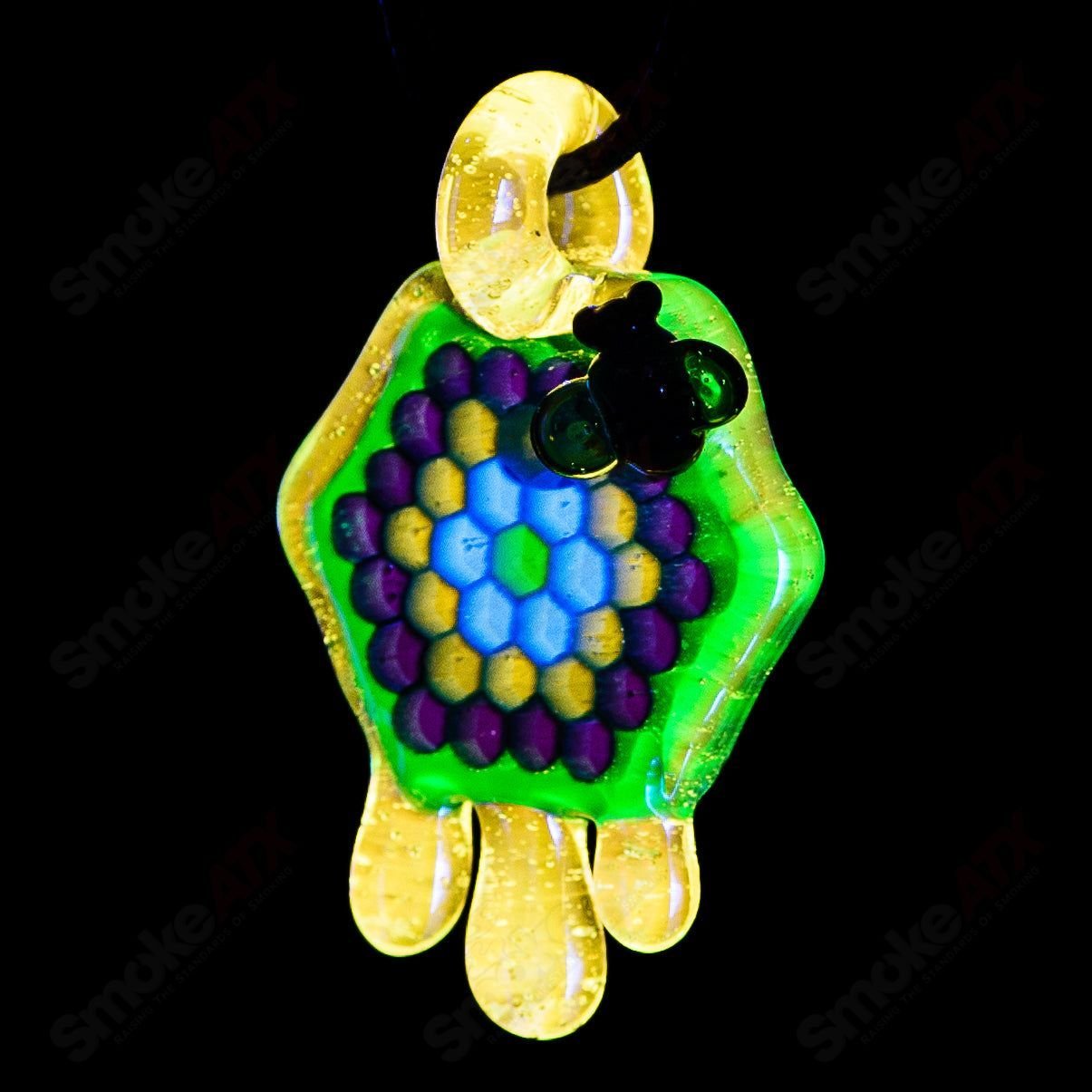 Joe P Glass 2-inch honeycomb drip pendant in teal, UV green, and yellow, featuring a vibrant heady glass design.