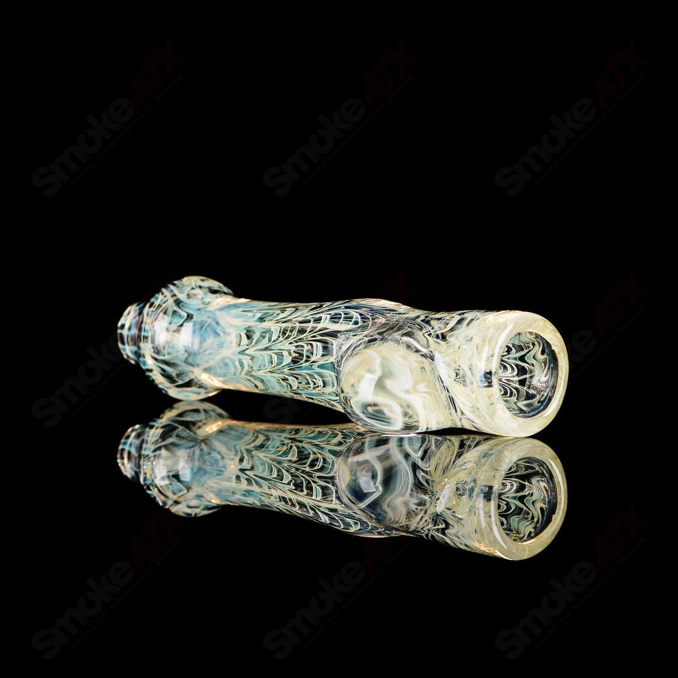 Transparent JMK Glass chillum with worked design and clear dot signature, showcasing detailed craftsmanship in glass.