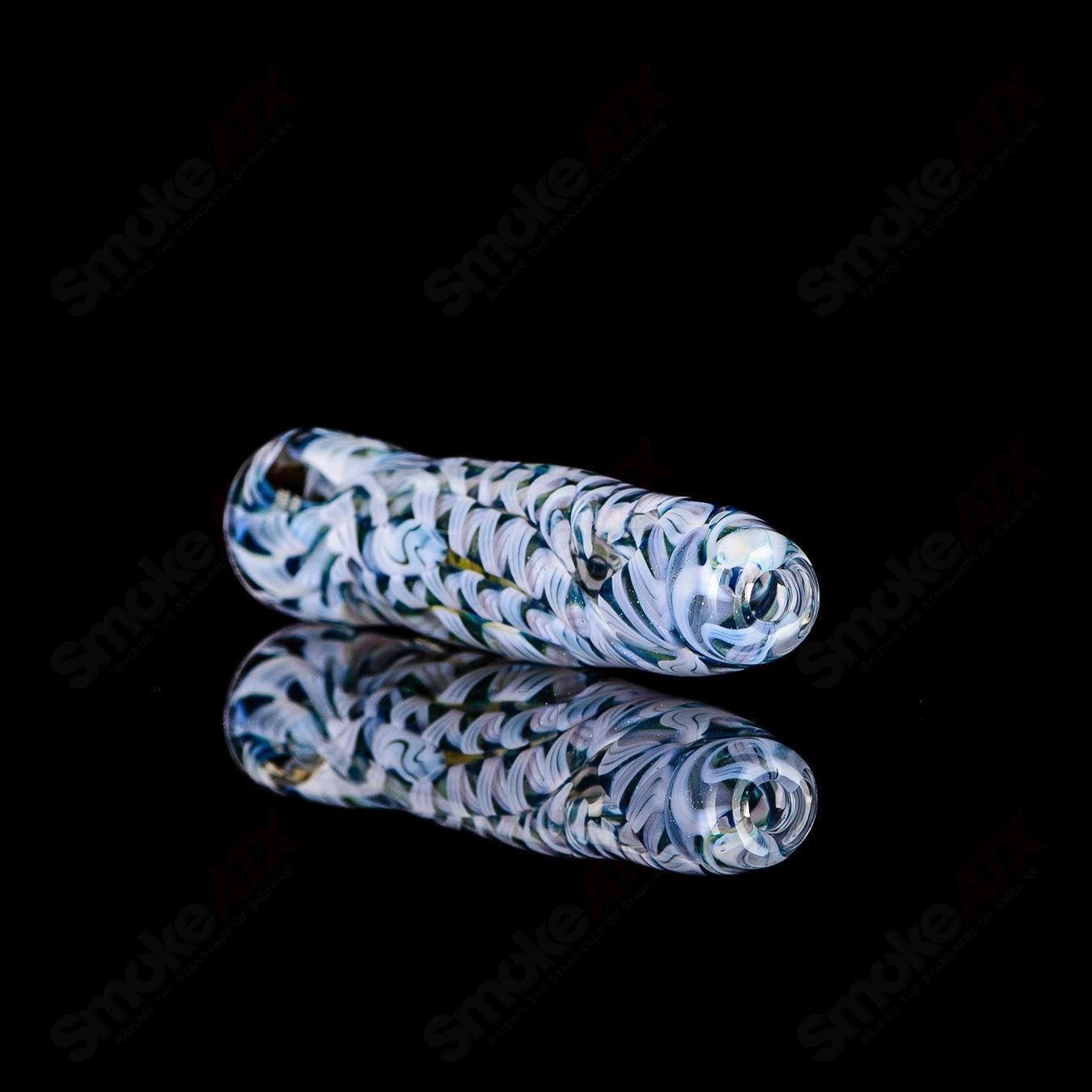 Glass chillum with signed JMK Glass branding, featuring intricate worked design and clear glass construction.