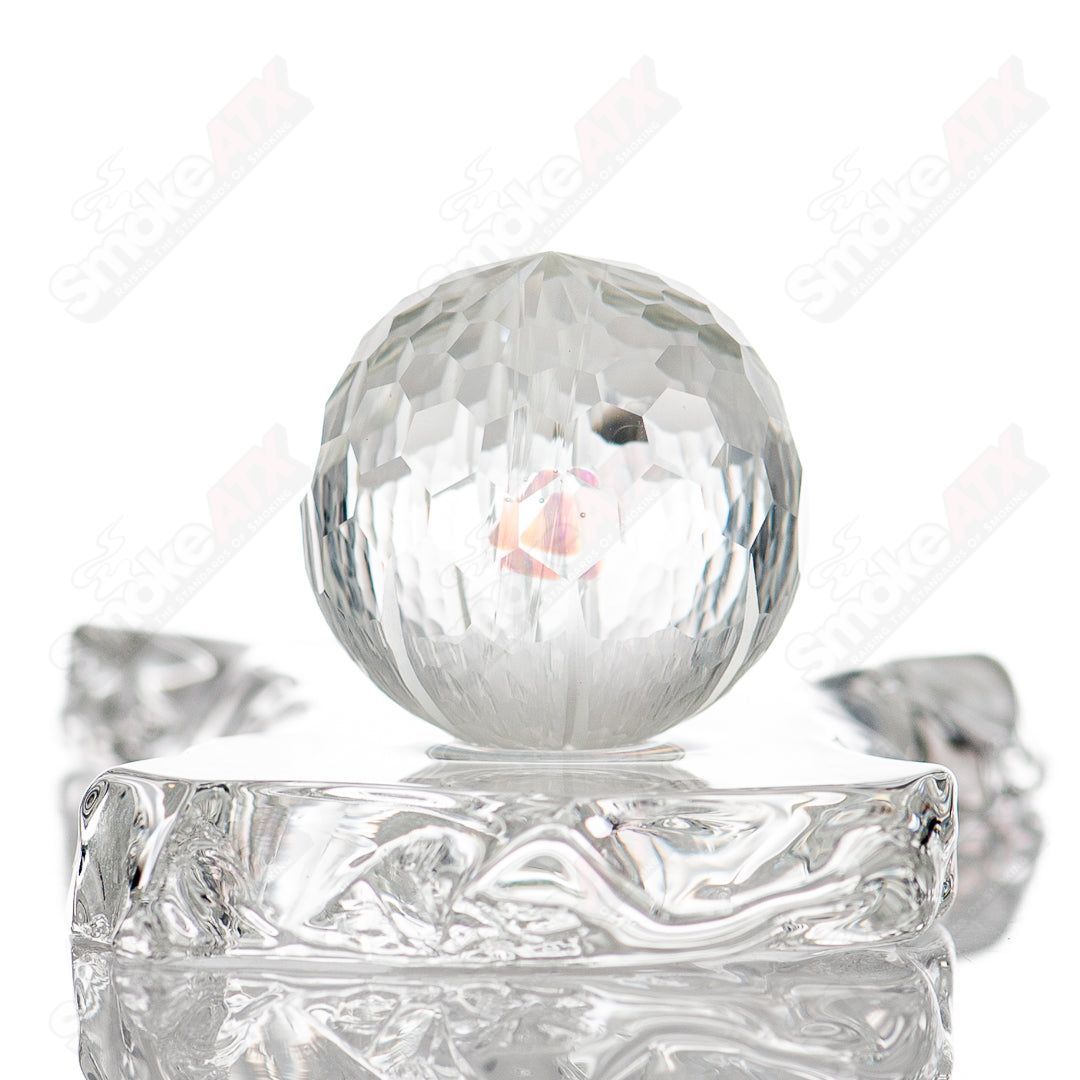 Close-up of colorful faceted marble glass marbles by Fatal Facets, featuring opal and marble patterns with a glossy finish.