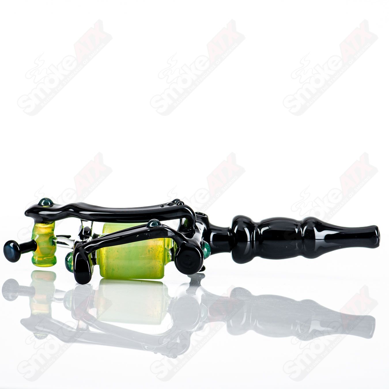 Black and slime-colored tattoo gun rig by JMass, a heady glass concentrate rig with intricate design and detailed glasswork.