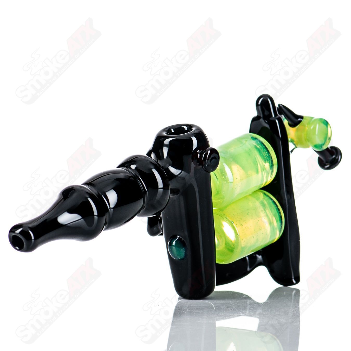 Black and slime-colored tattoo gun-shaped rig by JMass, a heady glass concentrate rig with intricate design details.