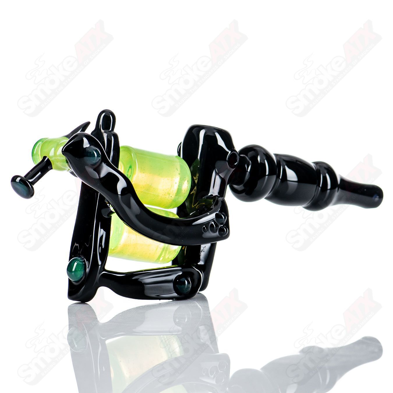 Black and slime-colored tattoo gun rig by JMass, a heady glass concentrate rig with detailed artistic design.