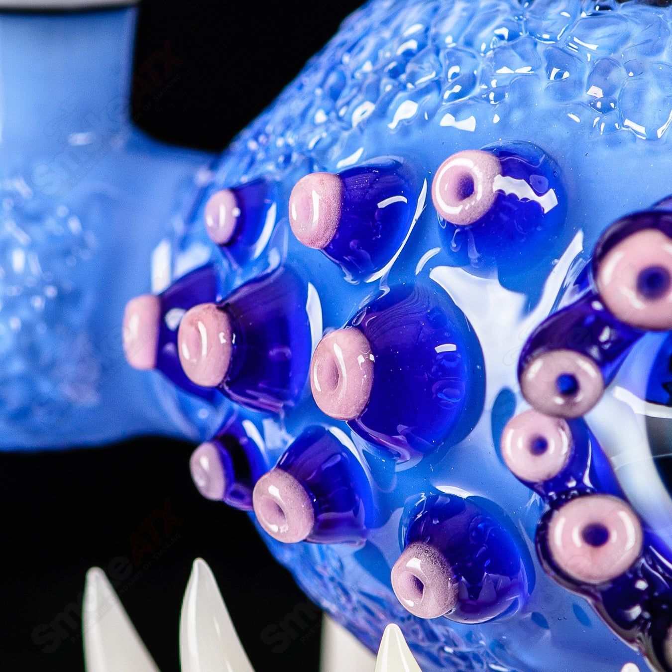 Brilliant blue orb-shaped concentrate rig by SALT & JAG, heady glass design with intricate glasswork and vibrant blue color.