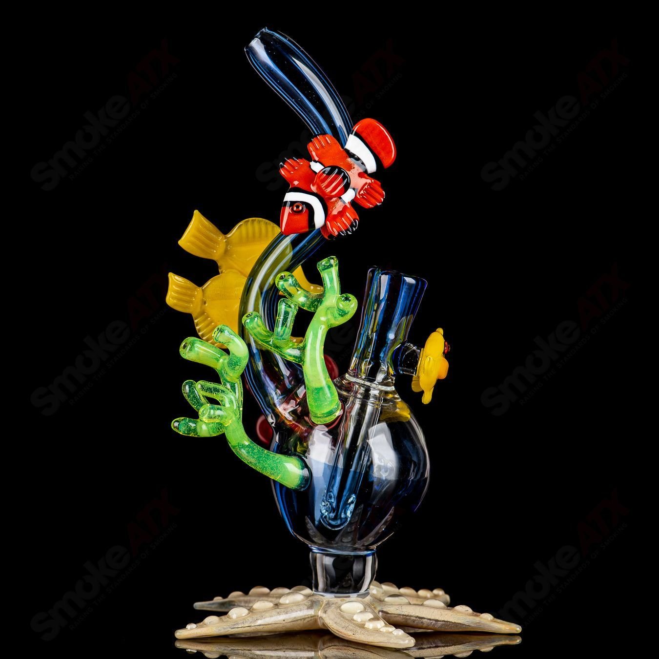 JRod Glass Coral Reef Rig, a colorful heady glass concentrate rig with intricate coral reef design and clear glass accents.