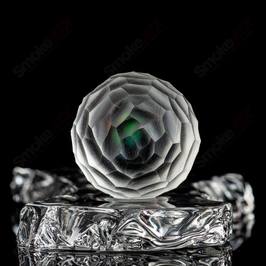 Faceted marble by Fatal Facets, handcrafted heady glass marble with intricate faceted design and smooth marble surface.