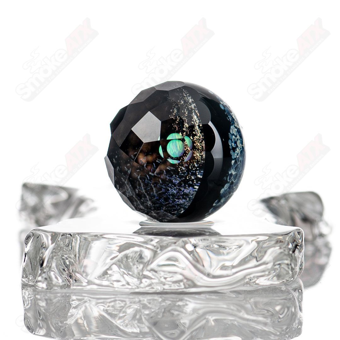 Glass marbles from the Fatal Facets x Eric Mort collab featuring distinctive marble patterns and smooth, rounded glass surfaces.