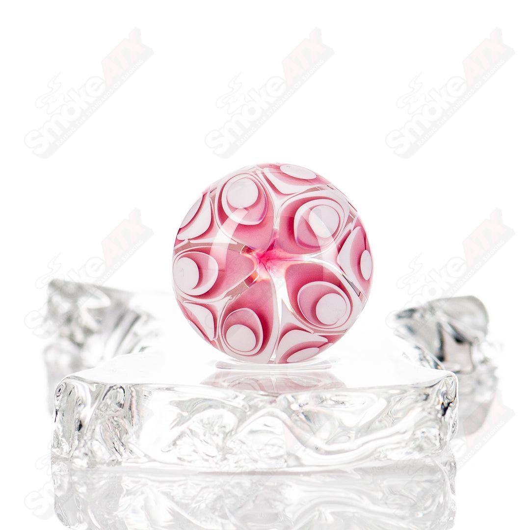 Golden ruby dotstack glass marble by Indo Glass, vibrant multicolor marble with intricate dot patterns on a clear glass surface.