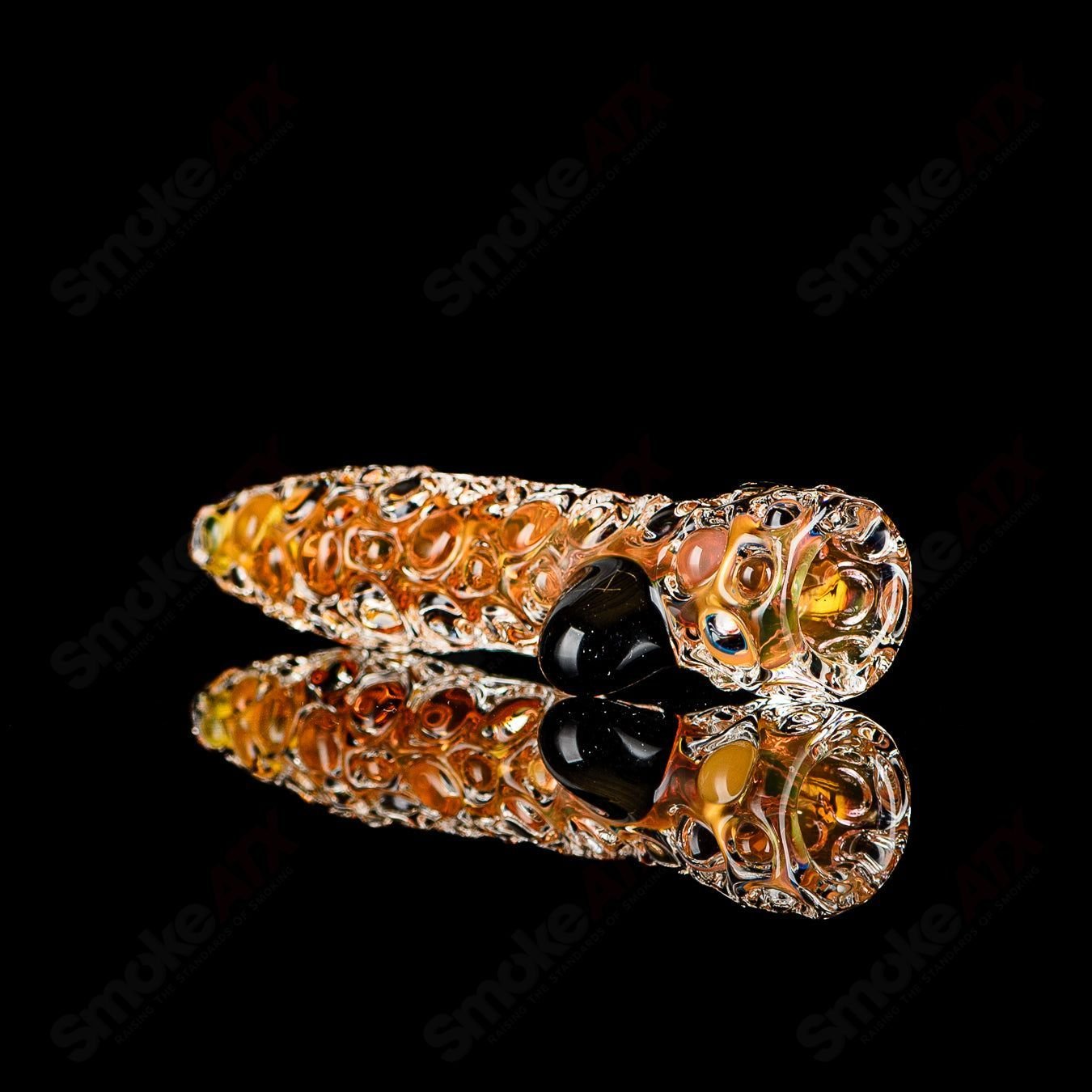 Fumed hobnail glass chillum with black dot signature by JMK Glass, detailed close-up of textured surface and craftsmanship.