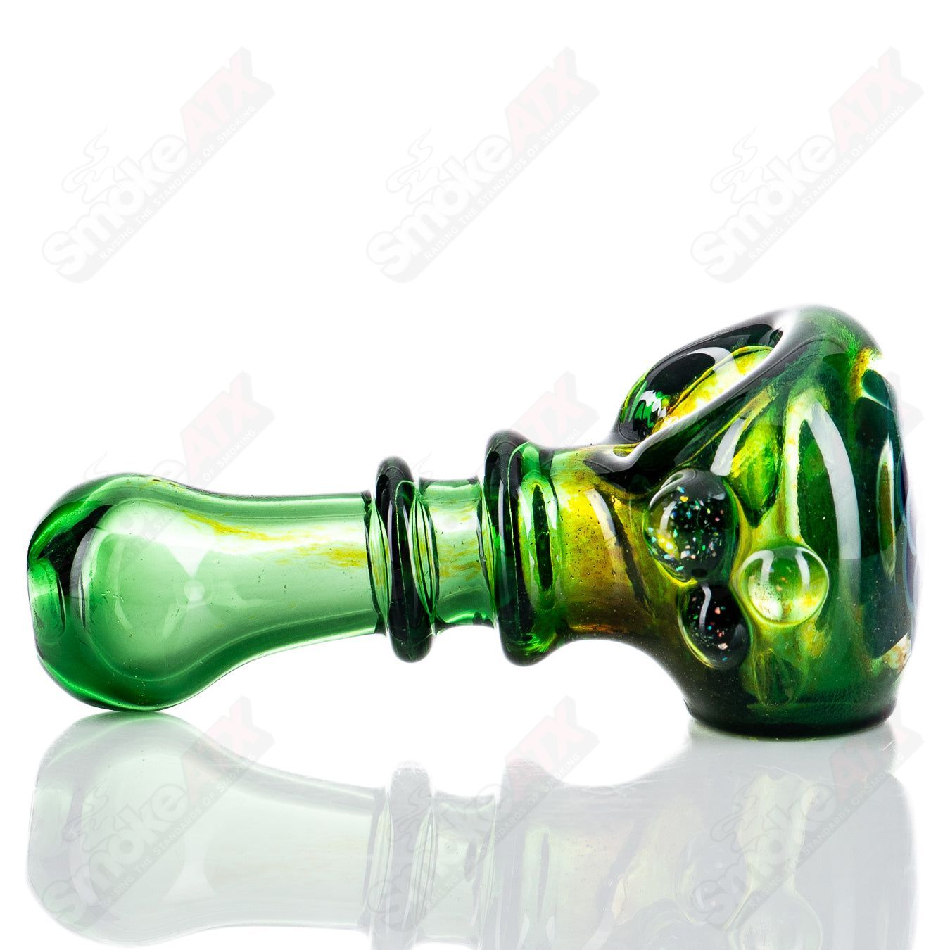 Green spoon-shaped hand pipe by JMass with crushed opal accents, part of the Tyme x JMass collection, made of high-quality heady glass.