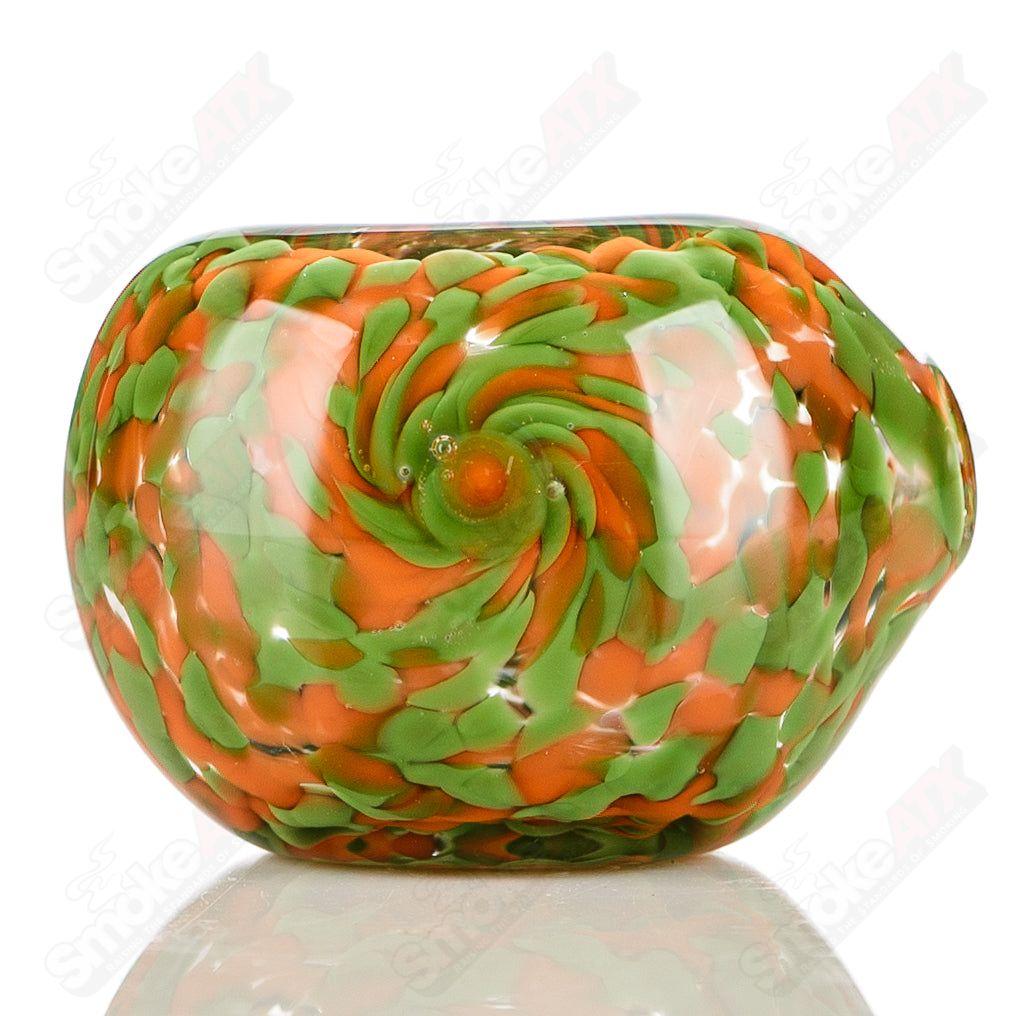 Green and orange Frit spoon pipe signed by JMK Glass, featuring colorful glass art and a smooth, rounded bowl.