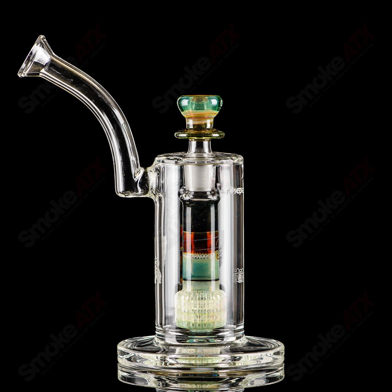 Mobius Ion Matrix V1 Accent Series glass bubbler with intricate design and colorful accents, featuring a clear glass body and mouthpiece.