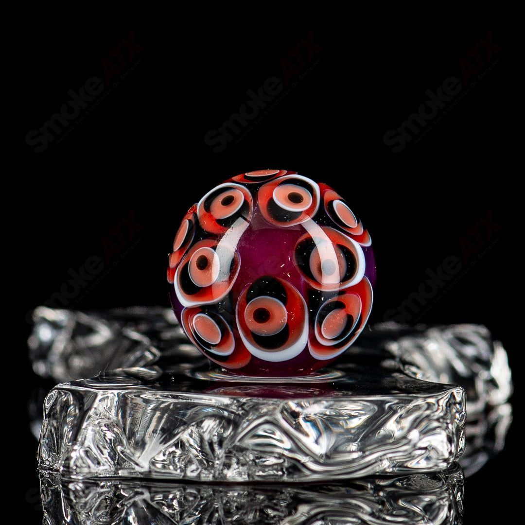 Red, black, and white dot stacked glass marbles by Indo Glass, showcasing vibrant, colorful glass marbles in a close-up view.